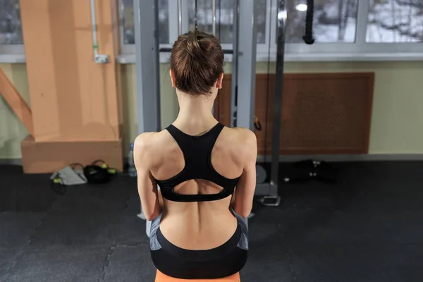 Spor salonunda makinede egzersiz ve kasları - kaslı atletik vücut Fitness modeli esneme genç kadın — Stok fotoğraf