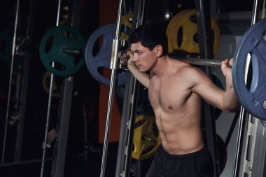 Barbell ile çalışma dışarı ağız kavgası yapan atletik erkek portresi yarım uzunluk.
