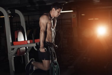 Paralel Çubuklar üzerinde yapıyor spor salonunda egzersiz kas vücut geliştiricisi. Athlitic erkek çıplak gövde.