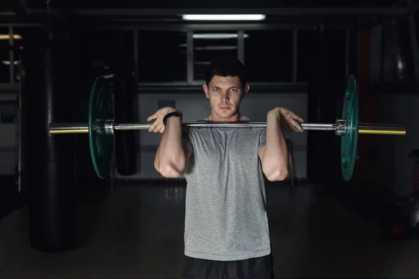 Spor salonunda ağırlık kaldıran genç bir vücut geliştirici.. — Stok fotoğraf