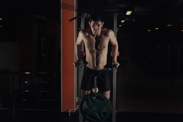Мышечный культурист тренируется в спортзале, делая упражнения на параллельных брусьях. Голый мужской туловище . — стоковое фото
