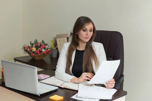 Красивая улыбающаяся деловая женщина, работающая за рабочим столом с документами . — стоковое фото