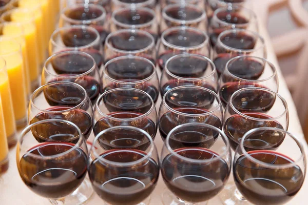 De nombreux verres de vin rouge prêts pour un banquet . — Photo