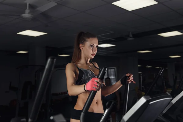 Jeune femme sexy pendant l'exercice sur le vélo au gymnase . — Photo