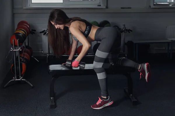 Menina fitness executar exercício com halteres, no músculo mais largo das costas . — Fotografia de Stock