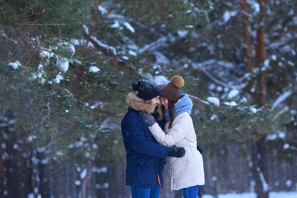Felice giovane uomo e donna abbraccia nella foresta invernale — Foto Stock