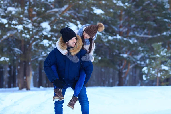 Jóvenes enamorados caminando en bosques nevados — Foto de Stock