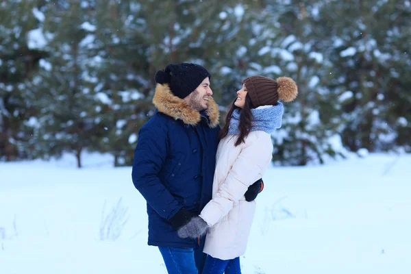 Szczęśliwa para trzyma ręce w zimowym lesie — Zdjęcie stockowe