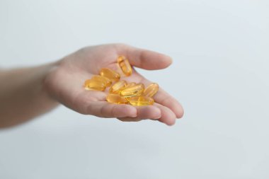 El kapsül Omega 3 beyaz zemin üzerine veriyor.