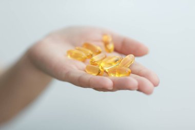 El kapsül Omega 3 beyaz zemin üzerine veriyor.
