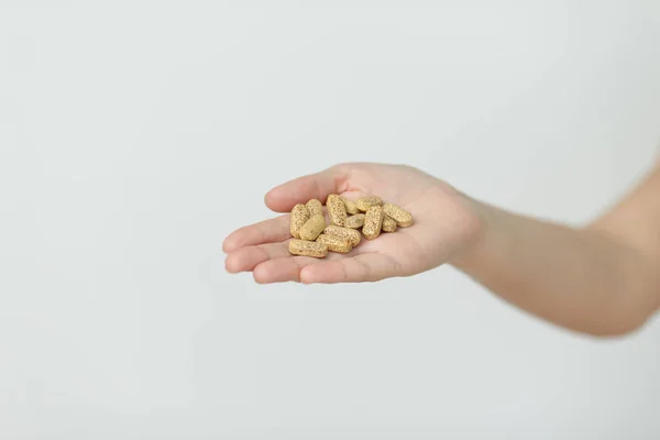 La mano está dando tabletas sobre fondo blanco . — Foto de Stock