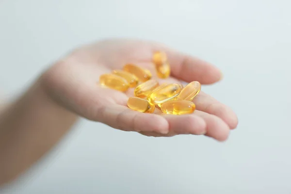 El kapsül Omega 3 beyaz zemin üzerine veriyor.