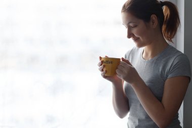 yazıt kahve vasıl pencere ile sarı bir fincan güzel kızla.