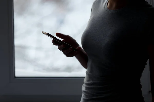 Manos de mujer usando móvil, teléfono inteligente en el fondo de la casa de ventana de vidrio . —  Fotos de Stock