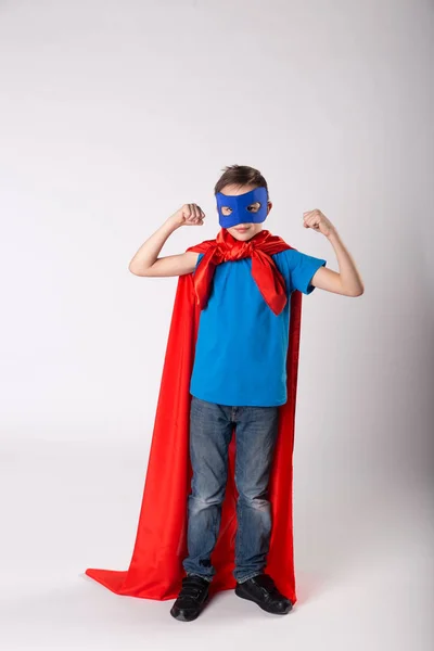 Juguetón superman niño posando y muestra su músculo — Foto de Stock