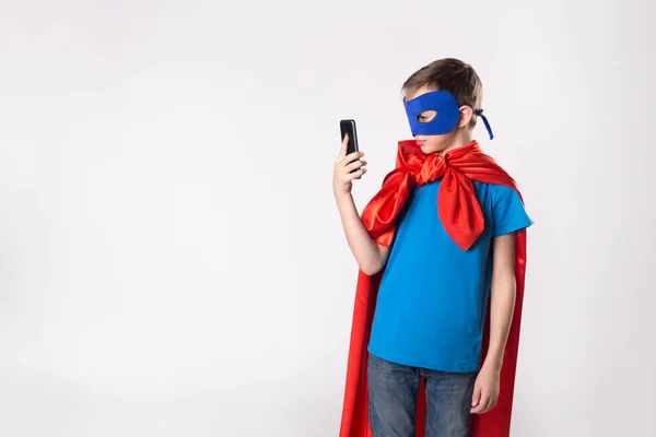 Superhéroe niño usando el teléfono móvil — Foto de Stock