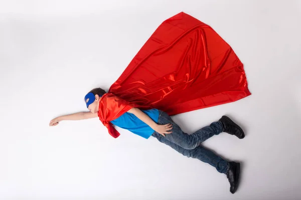 Мальчик-супергерой летит в костюме супермена — стоковое фото