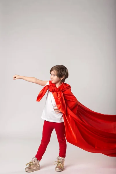 Niña fingir superhéroe en capa roja — Foto de Stock