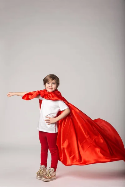 Niña fingir supermujer en capa roja — Foto de Stock