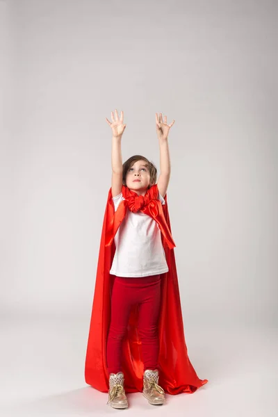 Superwoman niña en capa roja levantó las manos — Foto de Stock
