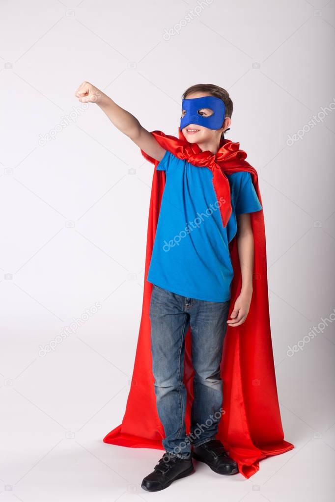 Superman child raised his hand up, pretend flying