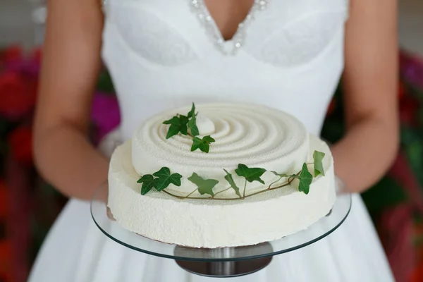 Primer plano de la novia hermosa sosteniendo un pastel de boda . —  Fotos de Stock