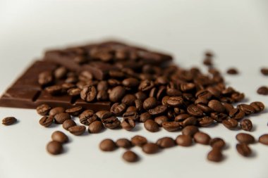 yakın çekim kahve çekirdekleri ve beyaz zemin üzerine çikolata.