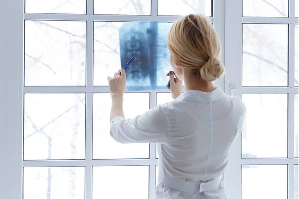 Mujer hermosa joven médico con estetoscopio y rayos X . — Foto de Stock