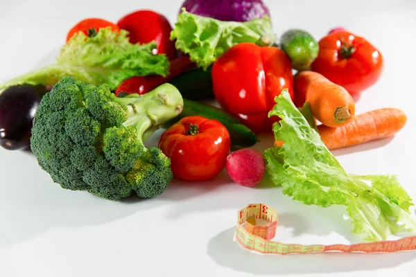 Verduras y cinta métrica, bodegón aislado sobre fondo blanco — Foto de Stock