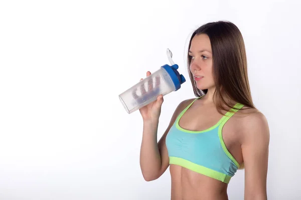 Тонкая фитнес-женщина пьет воду из спортивной бутылки — стоковое фото