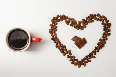 fincan sıcak kahve ve kahve çekirdekleri beyaz masasına kalp