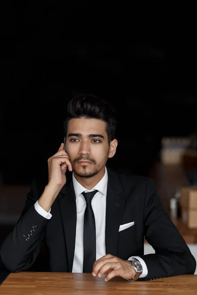 Hombre de negocios guapo de traje hablando por teléfono en la cafetería — Foto de Stock
