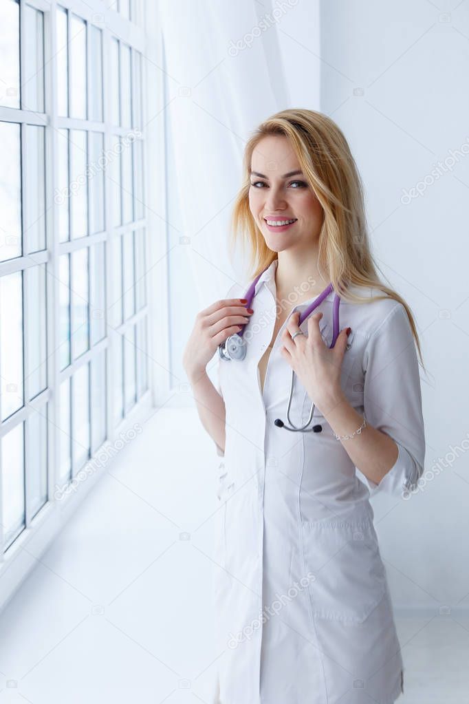 Doctor woman is standing in the near window