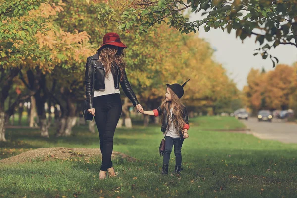 Madre e figlia che camminano tenendosi per mano al parco . — Foto Stock