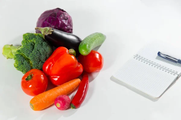 Colección de verduras frescas y cuaderno con plan de dieta aislado sobre fondo blanco . — Foto de Stock