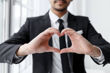 İş adamı eliyle kalp şekli göster.