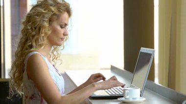 Kafede taşınabilir dizüstü bilgisayar ile eğlence süre içinde oturan genç güzel kadın.