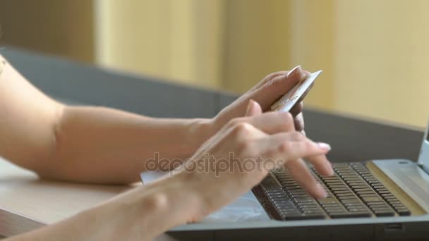 Close-up womans hands holding a credit card and using computer keyboard for online shopping. — Stok Video