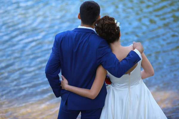 Boldog menyasszony és a vőlegény ölelés a háttérben tenger — Stock Fotó