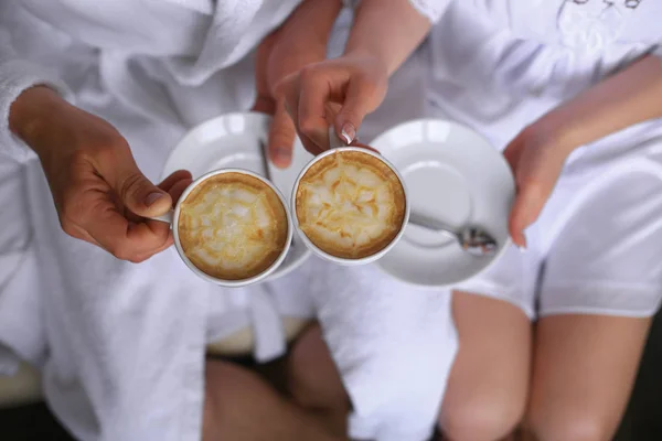 Loving birkaç otel odasında bir tablo üzerinde kahve bardağı tutan eller.