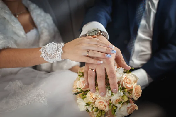 Kezében a menyasszony és a vőlegény esküvői csokor gyűrűk. — Stock Fotó