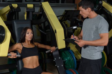 Kadın workuot egzersiz makinede eğitmen ile