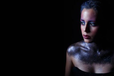 Moda fotoğraf siyah elbiseli güzel bir genç kadın. siyah arka plan üzerine kozmik kız.