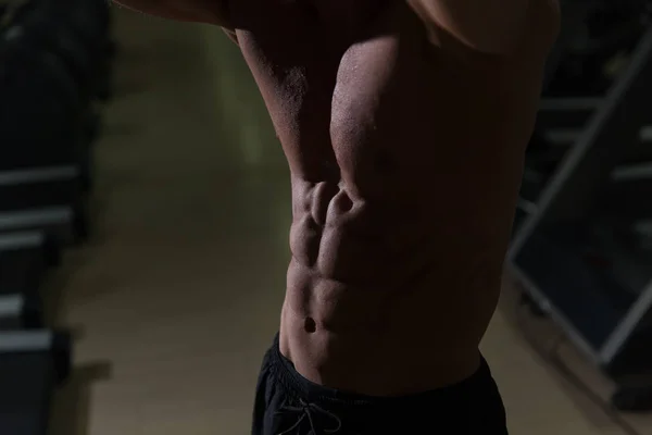 暗い部屋でダンベル トレーニングを筋肉の男 — ストック写真