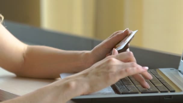 Close-up mulheres mãos segurando um cartão de crédito e usando teclado do computador para compras on-line. — Vídeo de Stock