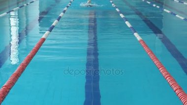 genç kadın gözlük ve kap mavi su kapalı yarış havuzda kelebek kontur stili