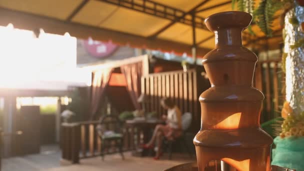 Choklad fontän placeras på ett bord i bröllopsdag eller fest i sommarterrass — Stockvideo