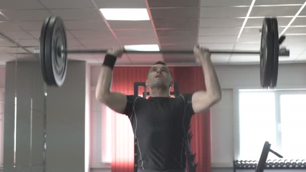 Athlète homme effectuant des squats aériens et pousser dans la salle de gym — Video