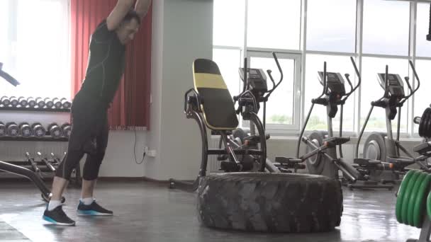 Sport Fitness Hombre golpeando neumático de rueda con martillo Sledge en el gimnasio — Vídeo de stock