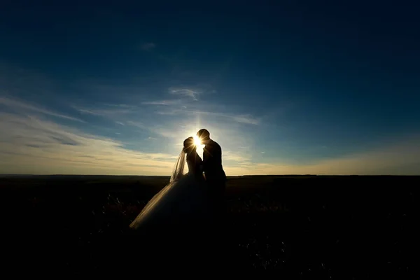 Couple de mariage embrasser sur le coucher du soleil . — Photo